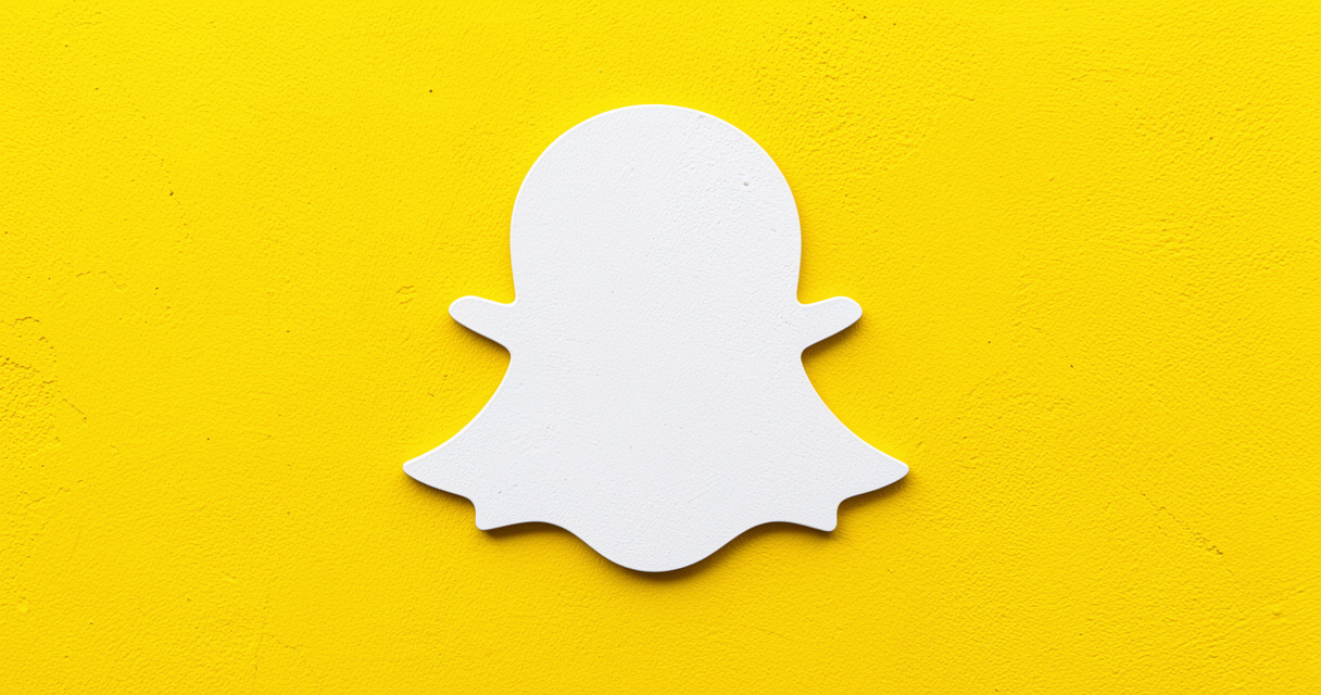 Mur jaune avec le fantôme blanc du logo Snapchat, illustrant la couleur officielle et le design minimaliste.